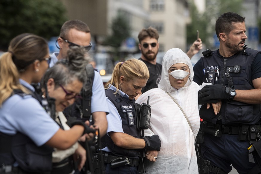 Polizisten fuehren die Klimaaktivisten der Organisation Clima Justice am Eingang der Schweize Bank rCredit Suisse ab, aufgenommen am Montag, 8. Juli 2019 auf dem Paradeplatz in Zuerich. (KEYSTONE/Enni ...