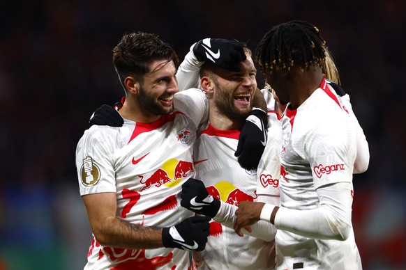 epa10443076 Leipzig's Konrad Laimer (C) celebrates with teammates Dominik Szoboszlai (L) and Mohamed Simakan (R) after scoring the 2-0 goal during the German Cup round of 16 soccer match between RB Le ...