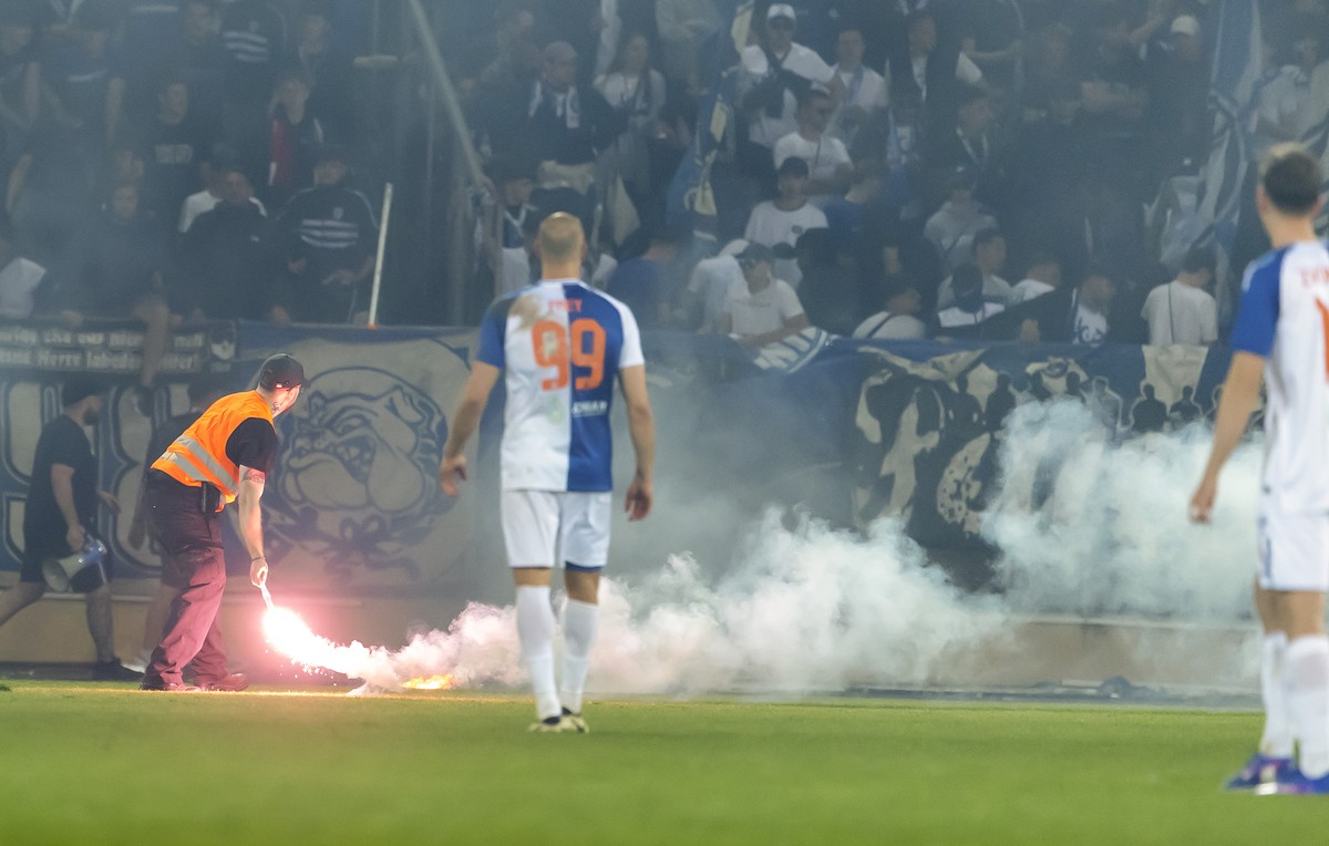 A security member removes a light smoke flare launched by Grasshoppers ultras onto the pitch after Lausannes players scored the 2:0, during the Swiss Cup semifinal between FC Stade Lausanne-Ouchy, S ...