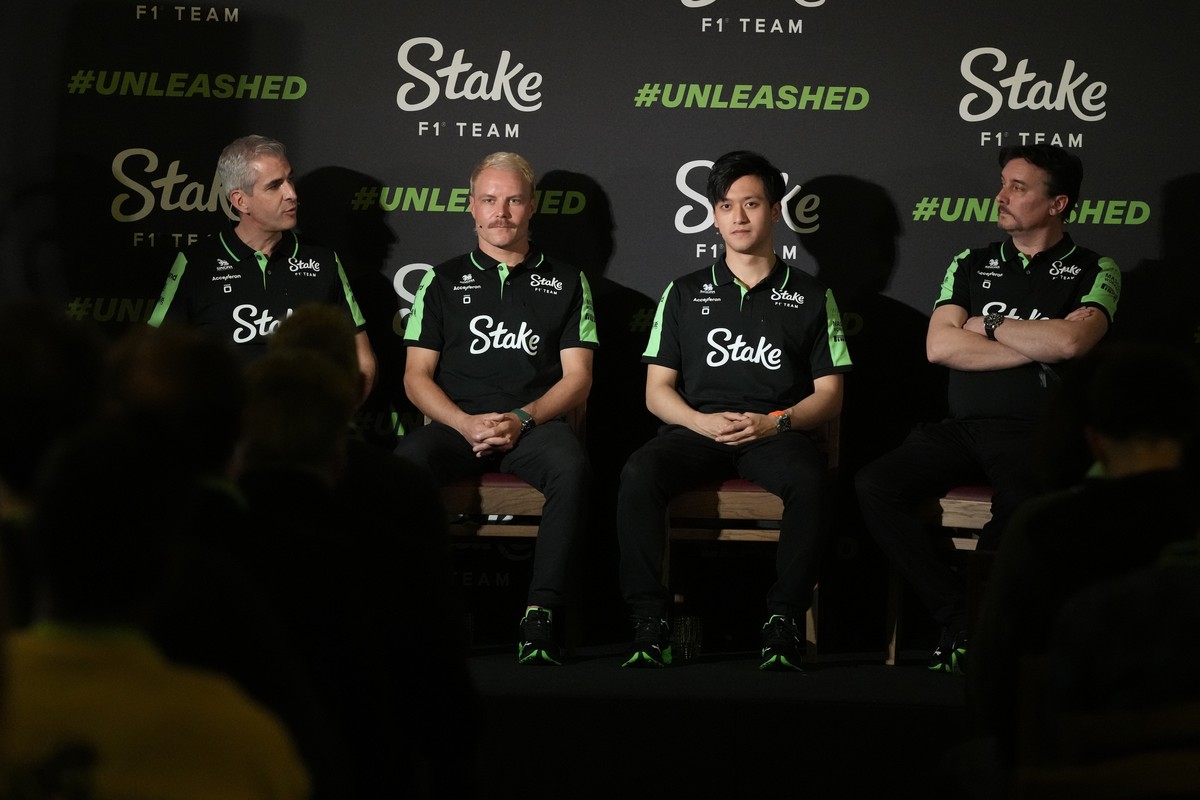Stake F1 Team Kick Sauber's Valtteri Bottas, second left, with teammate Zhou Guanyu, second right, and team principal Alessandro Alunni Bravi, left, and technical director James Kay speak at a me ...