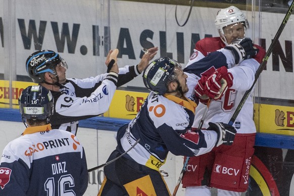 Garrett Roe, mitte, von Zug im Spiel gegen Phillippe Schelling, rechts, von Lausanne beim Eishockey Meisterschaftsspiel in der Qualifikation der National League zwischen dem EV Zug und dem HC Lausanne ...