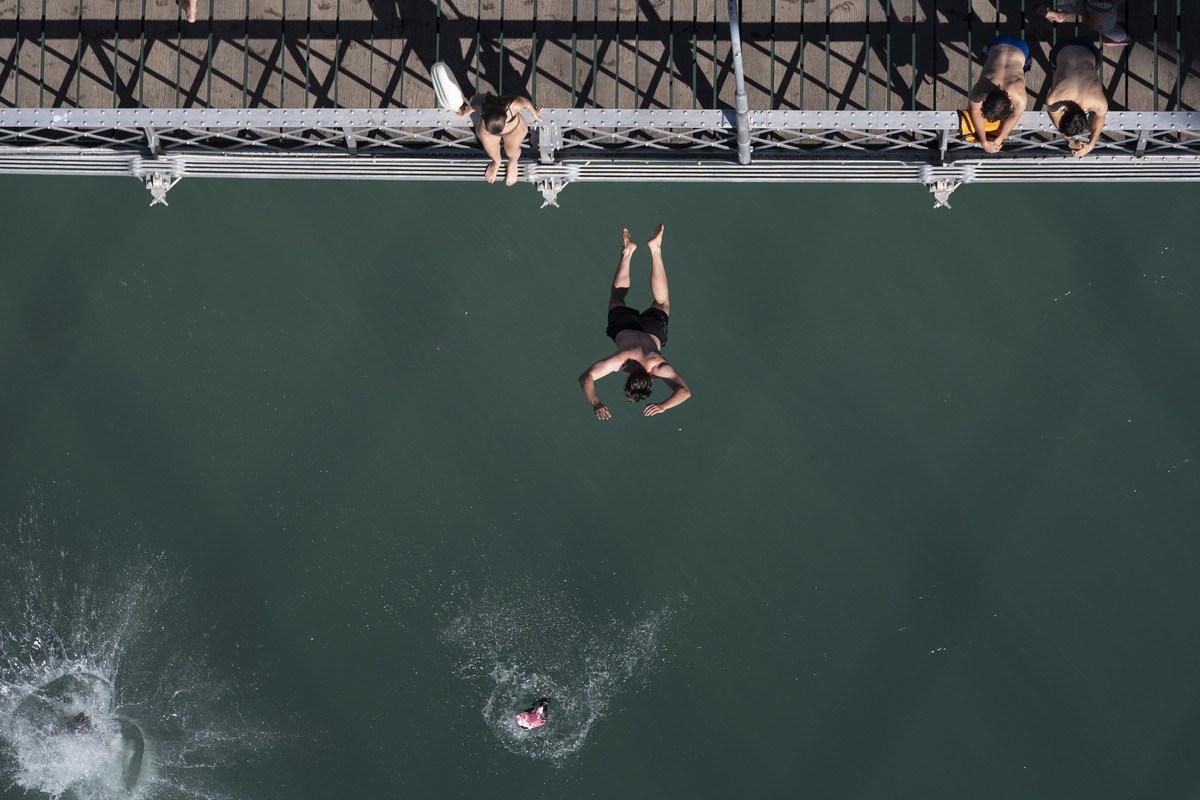 KEYPIX - Menschen springen vom Altenbergsteg in die Aare, fotografiert von der Kornhausbruecke aus, am Samstag, 4. Juli 2026 in Bern. (KEYSTONE/Gaetan Bally)