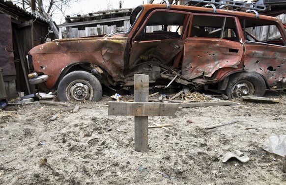 epaselect epa09874237 A grave is marked with a cross in the backyard of a private house in Hostomel in Kyiv (Kiev) area, Ukraine, 06 April 2022. Some cities and villages had recently been recaptured b ...