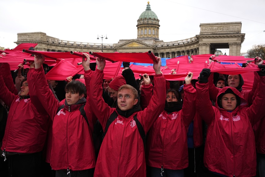 Young people rise squares of fabric in the colours of the Russian flag during a patriotic event to promote incoming National Unity Day, in St. Petersburg, Russia, Thursday, Nov. 2, 2023. (AP Photo/Dmi ...