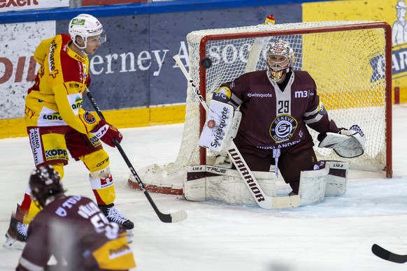 L&#039;attaquant biennois Tino Kessler, gauche, lutte pour le puck avec le gardien genevois Robert Mayer, droite, lors du premier match de la finale des play-off du Championnat de Suisse de hockey sur ...