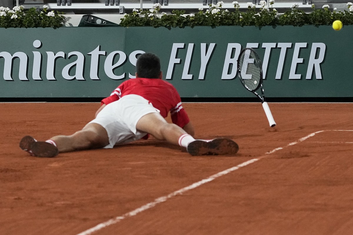 Serbia's Novak Djokovic falls as he plays Italy's Matteo Berrettini in a quarterfinal match of the French Open tennis tournament at the Roland Garros stadium Wednesday, June 9, 2021 in Paris ...