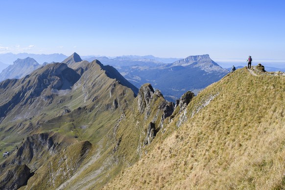 Two women walk on the Brienzer Rothorn Mountain, 2350 meters above sea level, in the Bernese Alps on the boundary between the Cantons of Berne and Lucerne, Switzerland, on Wednesday, October 10, 2018. ...
