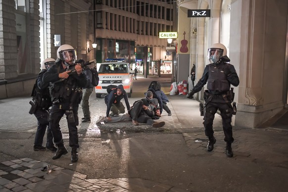 Polizisten nehmen einen Jugendlichen fest, am Freitag, 2. April 2021, in St. Gallen. In der St. Galler Innenstadt haben Jugendliche am Freitagabend die Polizei attackiert. Sie bewarfen die Einsatzkrae ...