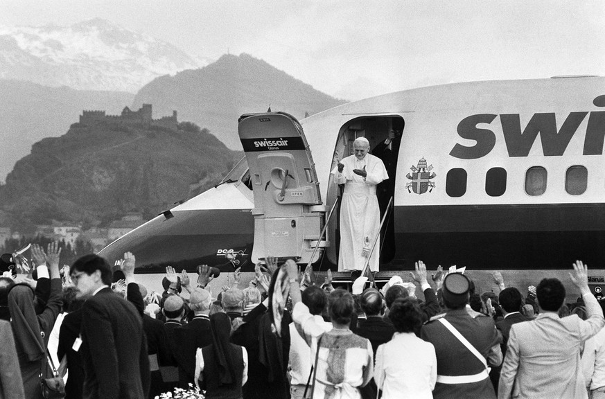 The door of the Swissair machine, a DC9, opens and an enthusiastic crowd begins to cheer; Pope John Paul II. is welcomed very warmly upon his arrival at the airport in Sion in the canton of Vaud, Swit ...