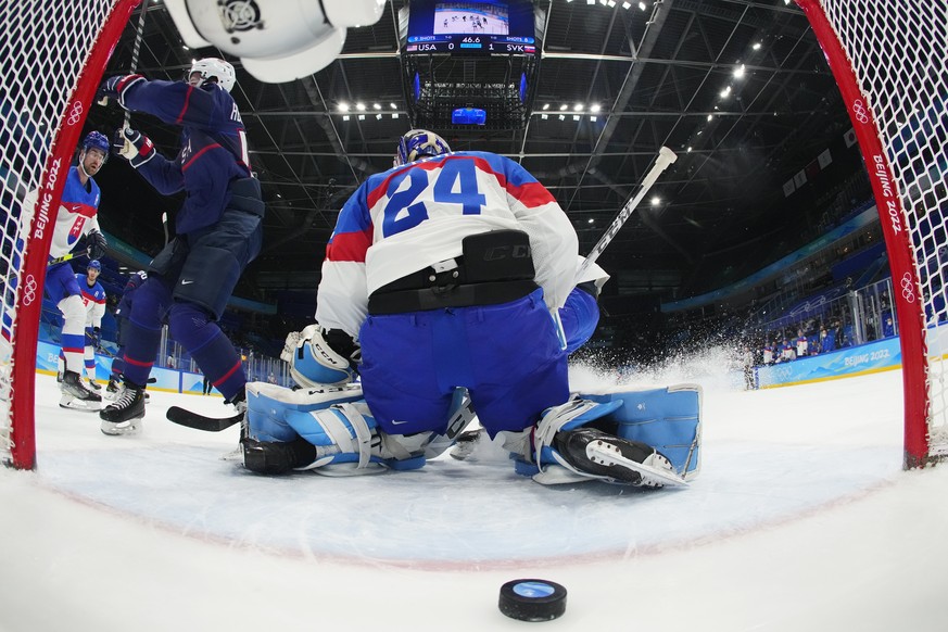 United States&#039; Nick Abruzzese, second from left, scores a goal against Slovakia goalkeeper Patrik Rybar (24) during a men&#039;s quarterfinal round hockey game at the 2022 Winter Olympics, Wednes ...