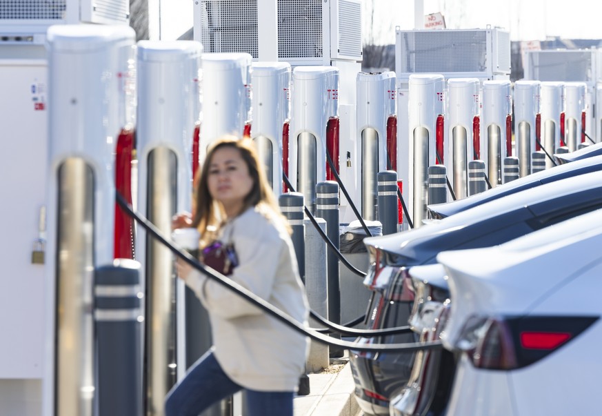 epa11054008 Tesla drivers recharge their vehicles at a Tesla Supercharger Station in Springfield, Virginia, USA, 02 January 2024. Though EV sales grew at a slower pace toward the end of 2023, a record ...