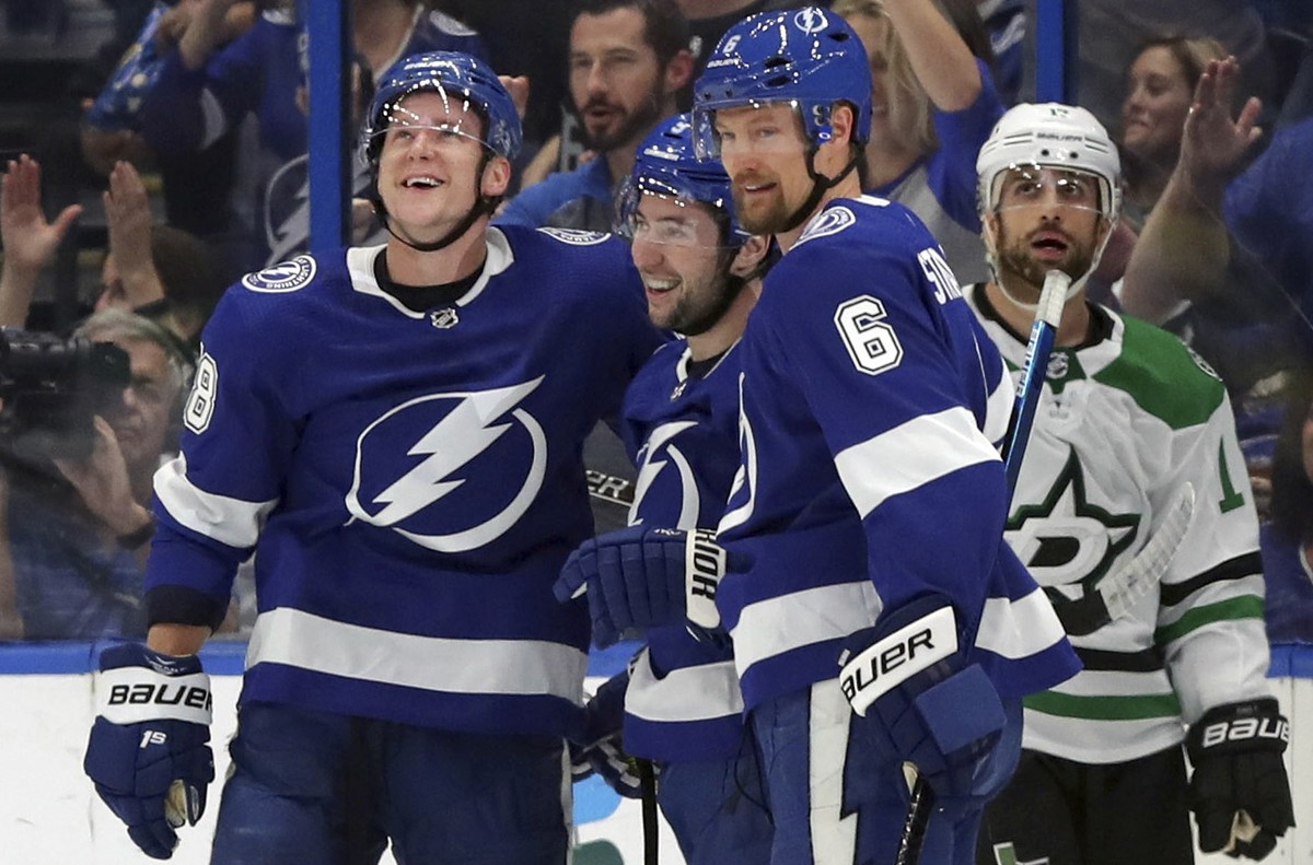 Tampa Bay Lightning's Ondrej Palat, of the Czech Republic, Tyler Johnson, and Anton Stralman, of Sweden, celebrate a goal as Dallas Stars' Andrew Cogliano reacts during the first period of a ...