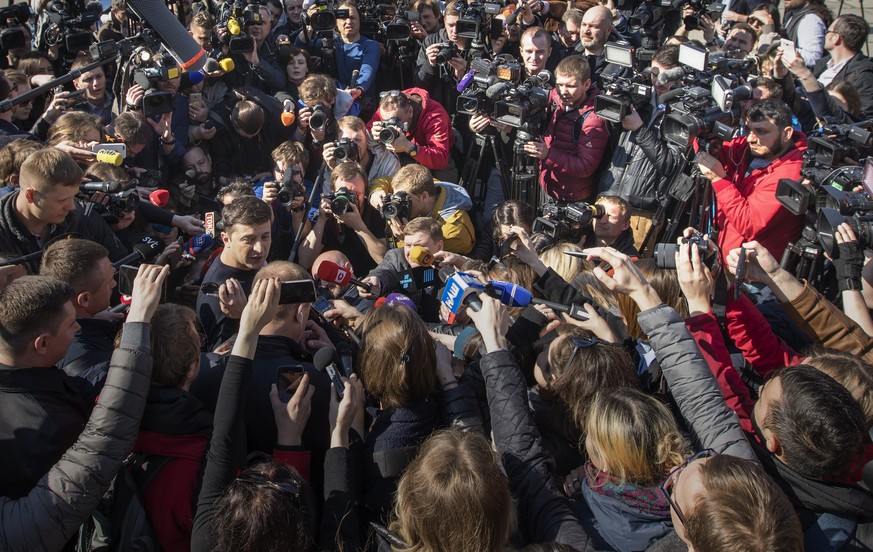 FILE - Ukrainian comedian and presidential candidate Volodymyr Zelenskyy, left, is surrounded by journalists after voting at a polling station, during the presidential elections in Kiev, Ukraine, Marc ...