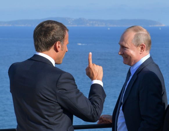 FILE - French President Emmanuel Macron, left, talks with Russian President Vladimir Putin during their meeting at the fort of Bregancon in Bormes-les-Mimosas, southern France, Monday Aug. 19, 2019. ( ...