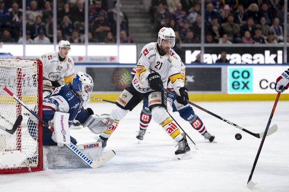 Zach Sanford (HCL), rechts, kaempft um den Puck mit Torhueter Simon Hrubec (ZSC), links, bei dem Spiel 1 des Playoff Viertelfinals der Eishockey National League zwischen den ZSC Lions und dem HC Lugan ...