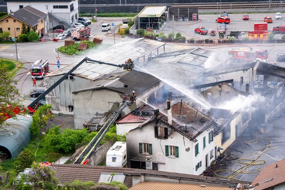Un pompier tente de maitriser les flammes lors d'un incendie ce lundi 20 avril 2026, a Saxon, Suisse. Un important incendie avec un fort degagement de fumee s'est declare lundi apres-midi da ...