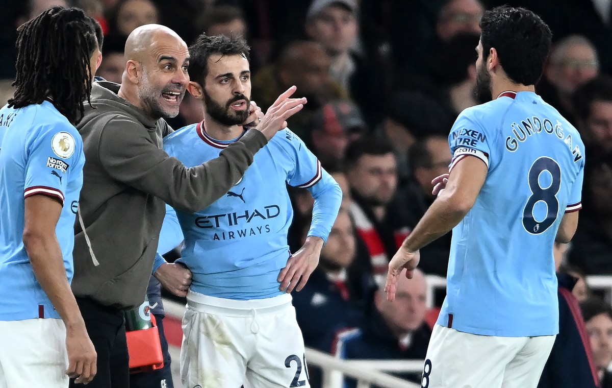 epa10469019 Manchester City manager Pep Guardiola talks to his players Nathan Ake (L), Bernardo Silva and Ilkay Guendogan (R) during a break in the English Premier League soccer match between Arsenal  ...