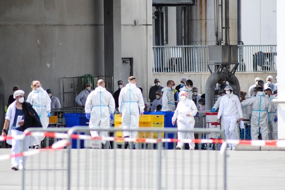 epa08497278 A handout photo made available by the German armed forces (Bundeswehr) shows soldiers taking coronavirus tests from workers at the Toennies meat factory in Rheda-Wiedenbrueck, western Germ ...