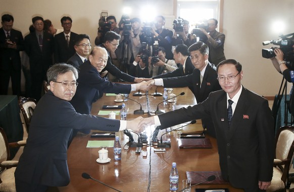 In this photo provided by South Korea Unification Ministry, South Korean Red Cross President Park Kyung-seo, second from left, shakes hands with his North Korean counterpart Pak Yong Il during a meeti ...