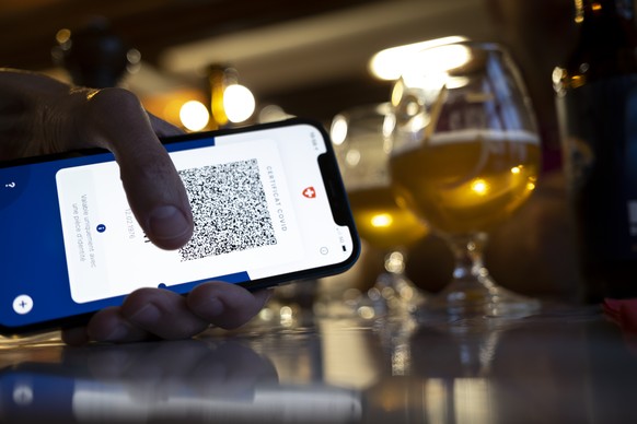 Une personne tient dans sa main un smartphone avec l&#039;application Certifact Covid suisse dans un restaurant ce vendredi 10 septembre 2021 a Rances dans le canton de Vaud. Des ce lundi 13 septembre ...
