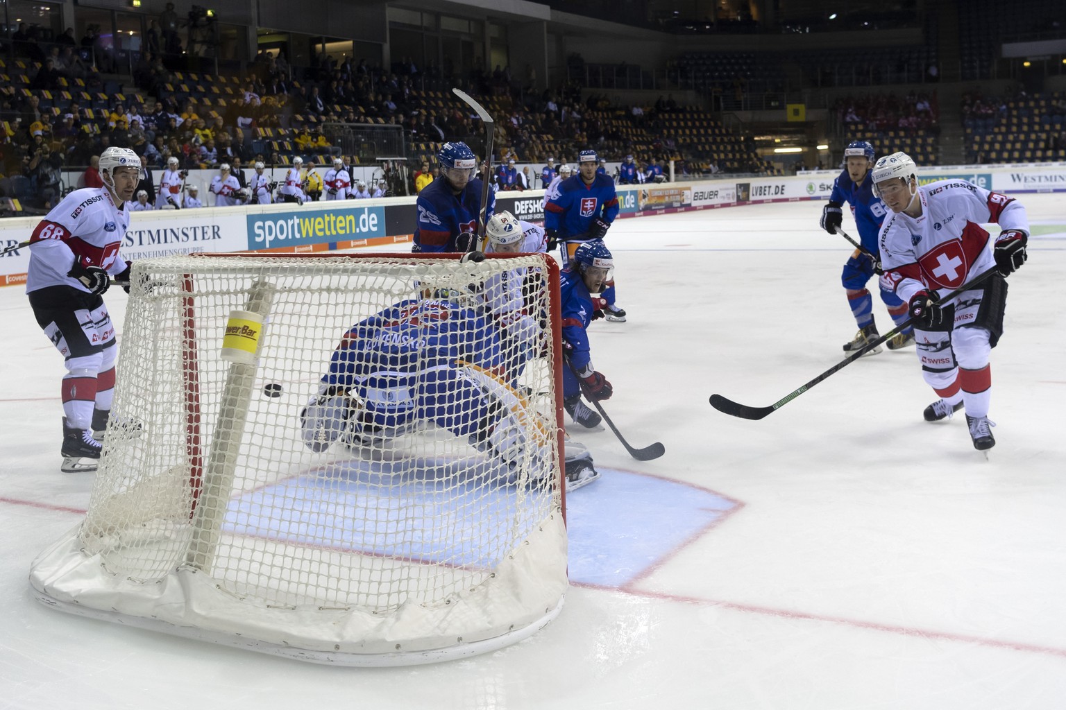 Switzerland&#039;s Dario Simion, right, scores during the Ice Hockey Deutschland Cup match between Slovakia and Switzerland at the Koenig Palast stadium in Krefeld, Germany, on Thursday, November 8, 2 ...