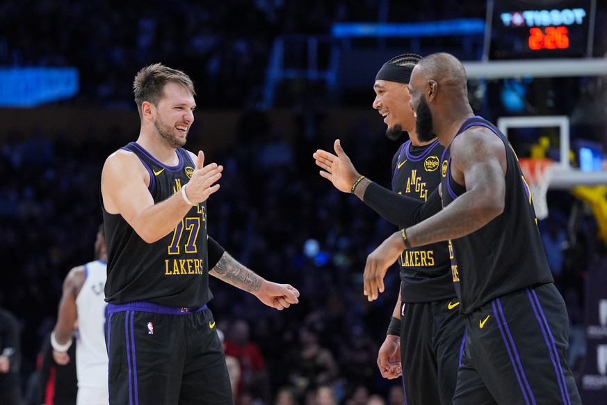 Los Angeles Lakers guard Luka Doncic, from left, center Jaxson Hayes and forward LeBron James (23) react to a play during the second half of an NBA basketball game against the Utah Jazz Tuesday, Nov.  ...