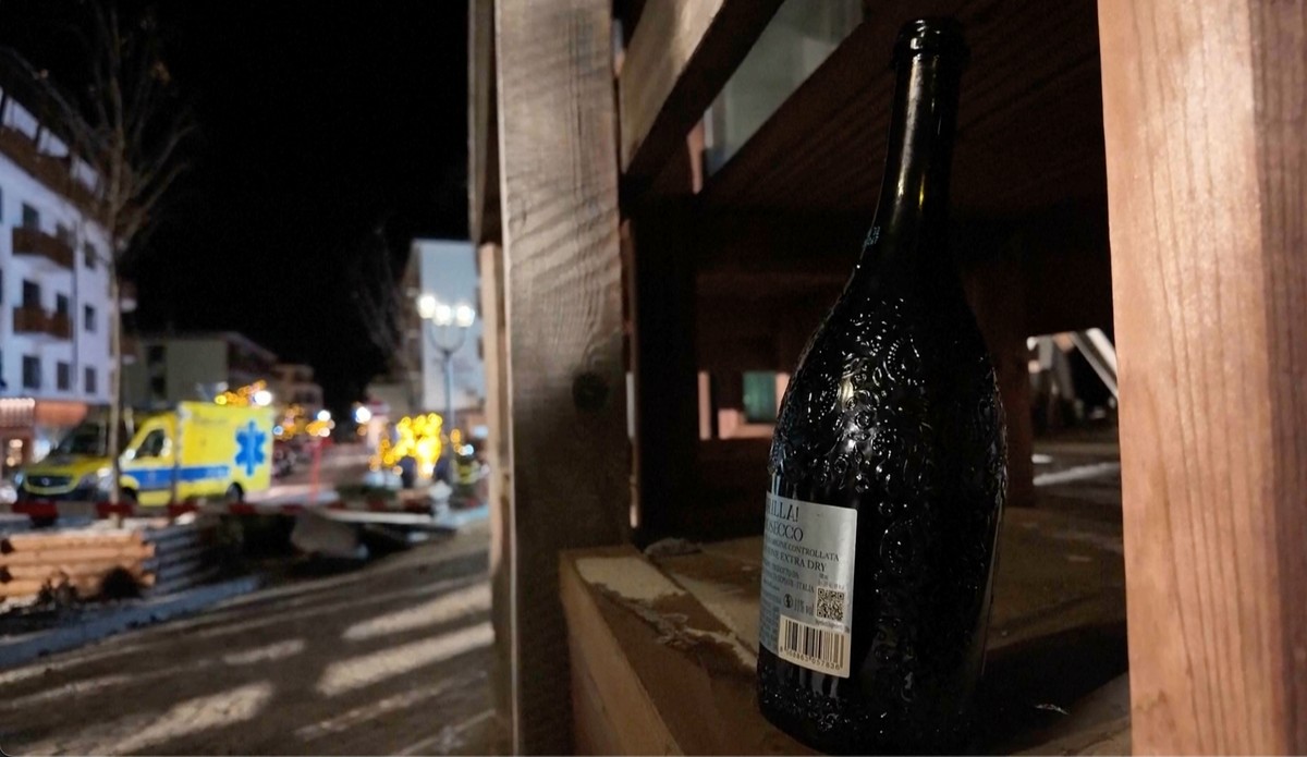 A bottle of sparkling wine lies where a fire broke out leaving people dead and injured, during New Years celebration, in Crans-Montana, Swiss Alps, Switzerland, Thursday, Jan. 1, 2026. (Police Canton ...