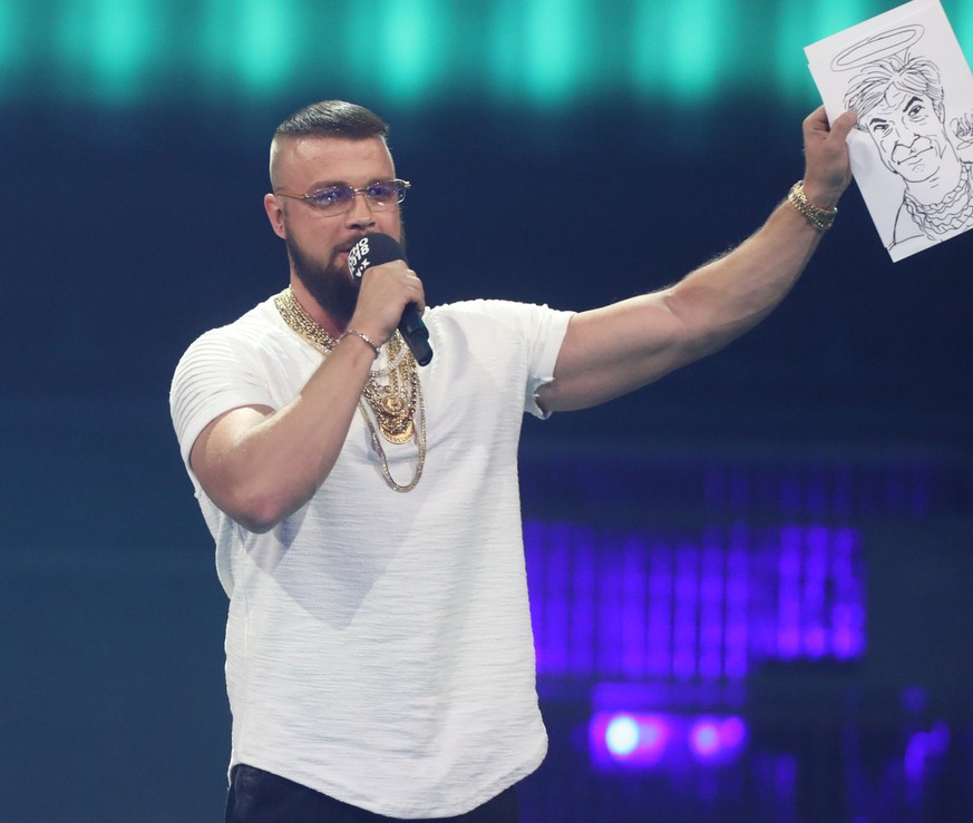 12.04.2018, Berlin: Kollegah (r) und Farid Bang erhalten den Echo Hip-Hop/Urban National bei der 27. Verleihung des Deutschen Musikpreises Echo. Die Rapper halten eine Karrikatur von Sänger Campino mi ...