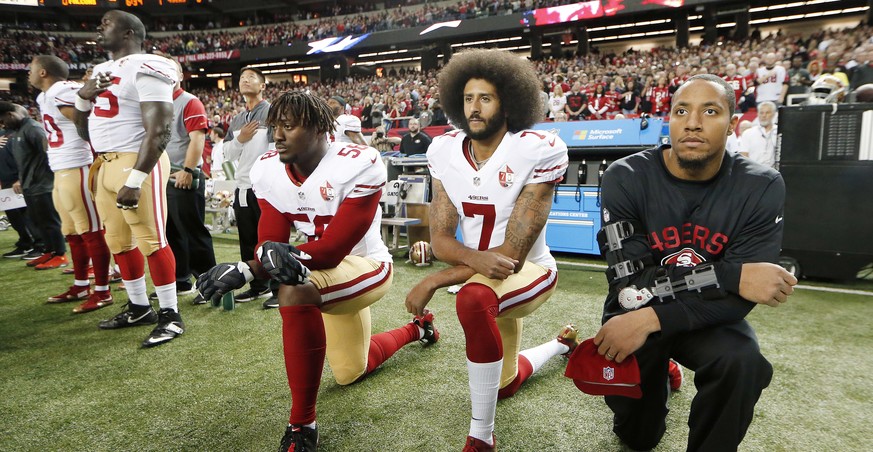 FILE - In this Dec. 18, 2016, file photo, San Francisco 49ers quarterback Colin Kaepernick (7) and outside linebacker Eli Harold (58) kneel during the playing of the national anthem before an NFL foot ...