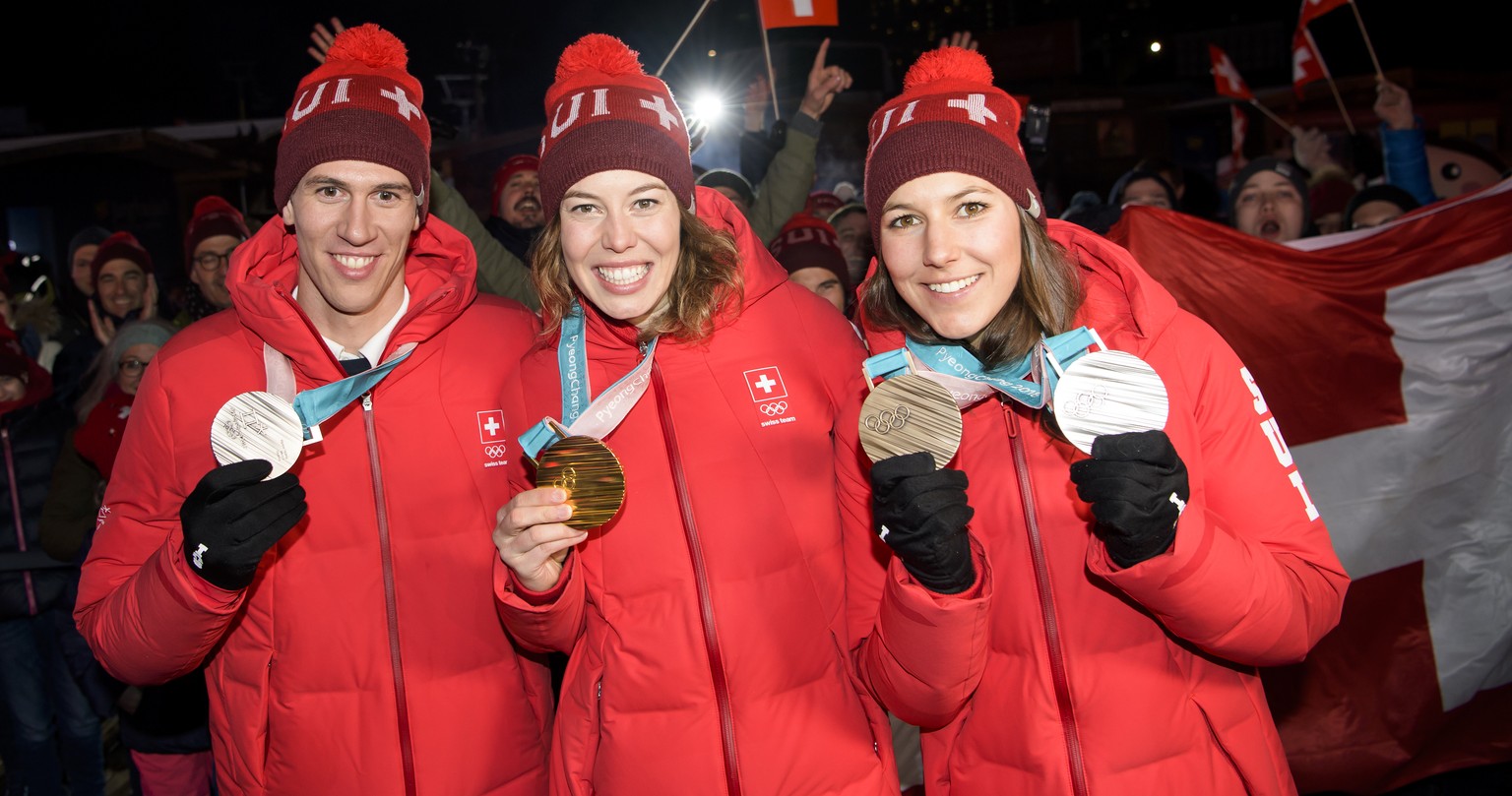 Silver medal winner Ramon Zenhaeusern of Switzerland, left, Gold medal winner Michelle Gisin of Switzerland, center, and Bronze and Silver medals winner Wendy Holdener of Switzerland, right, celebrate ...