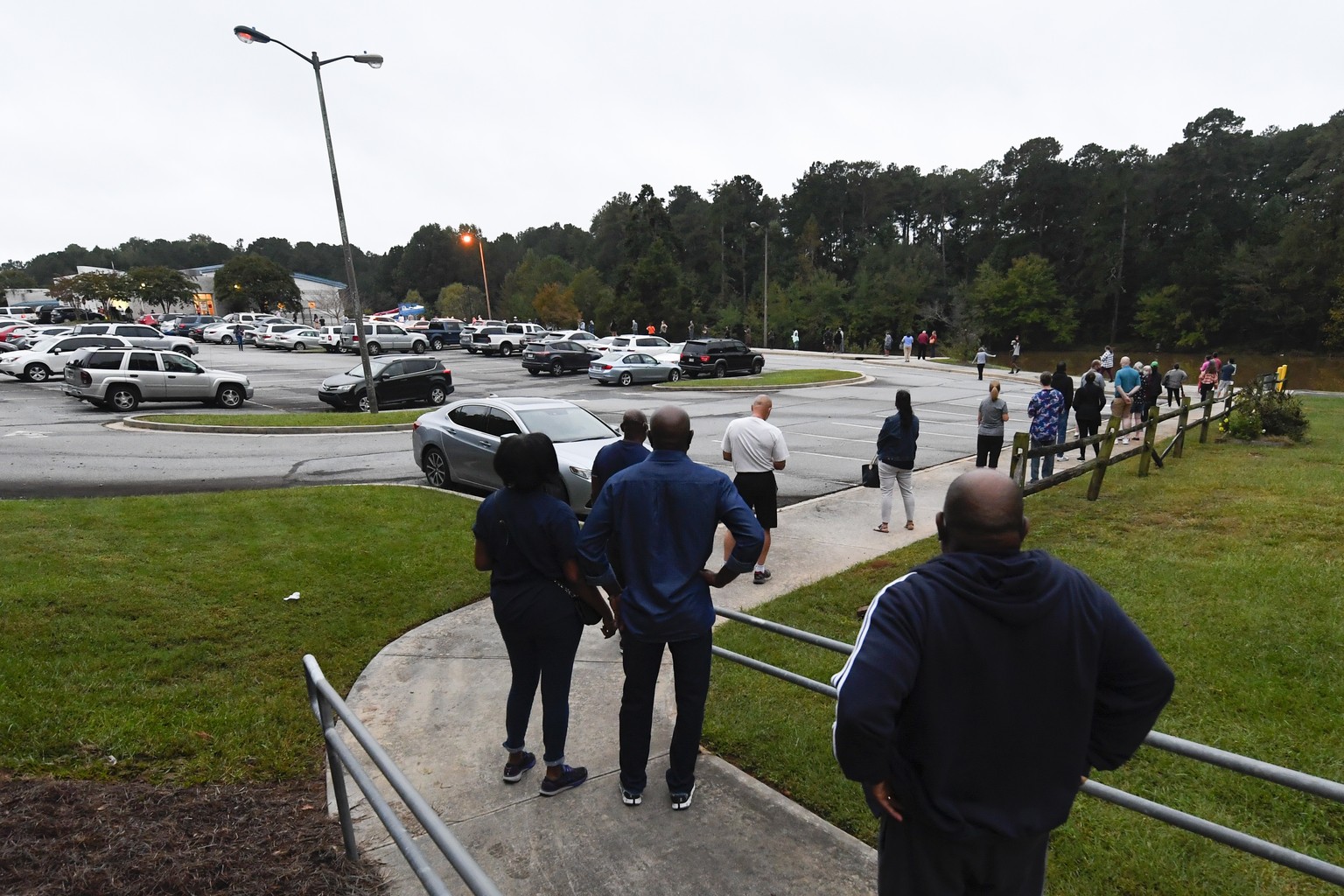 epa08738303 A line snakes through the parking lot as the first day of early voting gets underway on at the Mountain Park Activity Building in Stone Mountain, Georgia, USA, 12 October 2020. EPA/ATLANTA ...