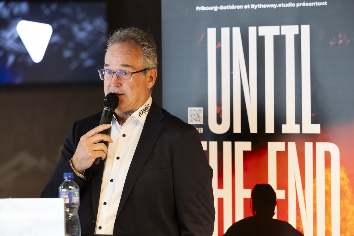 Trainer Patrick Emond spricht neben einem Filmplakat waehrend einer Medienkonferenz von Fribourg-Gotteron zur neuen Saison, am Montag, 2. September 2024, in Fribourg. (KEYSTONE/Peter Klaunzer)