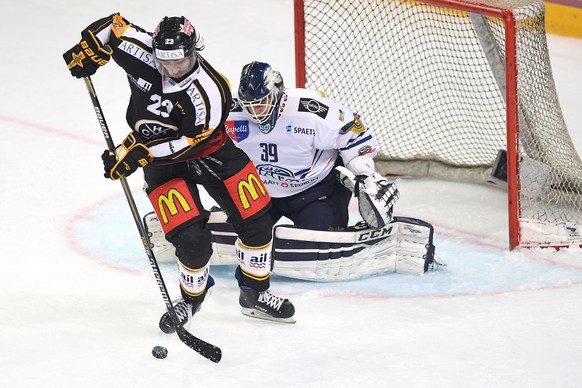 Luganos Giovanni Morini, links, im Spiel um den Puck gegen Ambris Torhueter Sandro Zurkirchen beim Eishockeyspiel der National League A zwischen dem HC Lugano und dem HC Ambri Piotta, in der Resega Ei ...