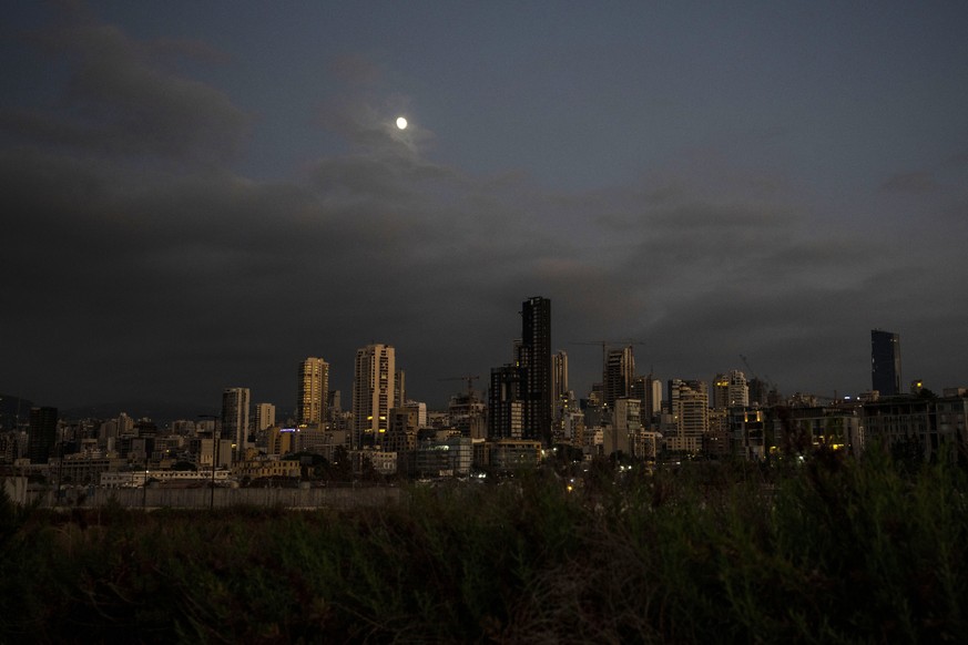 The moon rises over the capital city of Beirut as it remains in darkness during a power outage, Lebanon, Thursday, Aug. 19, 2021. Lebanon, which is mired in multiple crises including a devastating eco ...