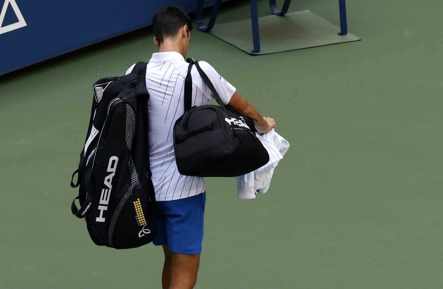 epa08651709 Novak Djokovic of Serbia walks off the court after he accidentally hit a linesperson with a ball in the throat during his match against Pablo Carreno Busta of Spain on the seventh day of t ...
