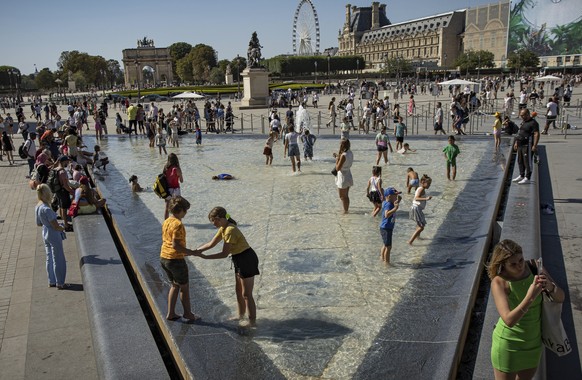 People take advantage of the pools near the Louvre Museum to refresh themselves, in Paris, France, Thursday, Aug. 11, 2022. France is this week in the midst of its fourth heat wave of the year as the  ...