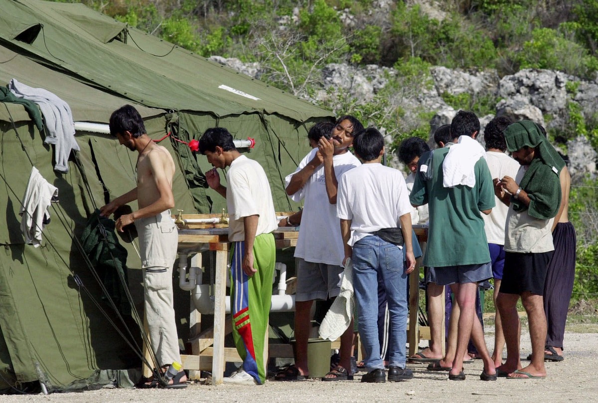 FILE - In this Sept. 21, 2001, file photo, men shave, brush their teeth and prepare for the day at a refugee camp on the Island of Nauru. The United States and Australia are close to announcing a deal ...