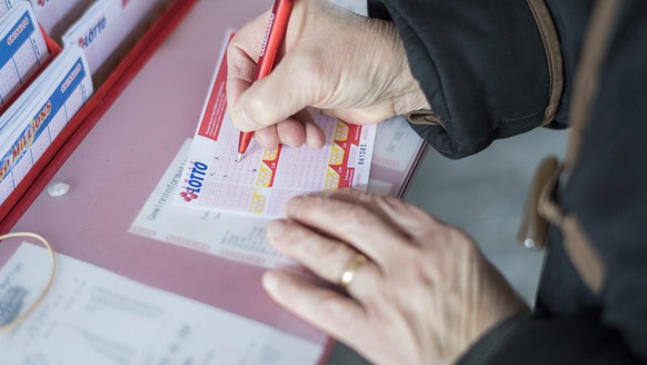 Eine Frau fuellt ein Los mit dem aktuellen Swiss Lotto Gewinn von 64.3 Millionen Franken aus, aufgenommen am Mittwoch 14. Dezember 2016, in Brugg. (KEYSTONE/Ennio Leanza)