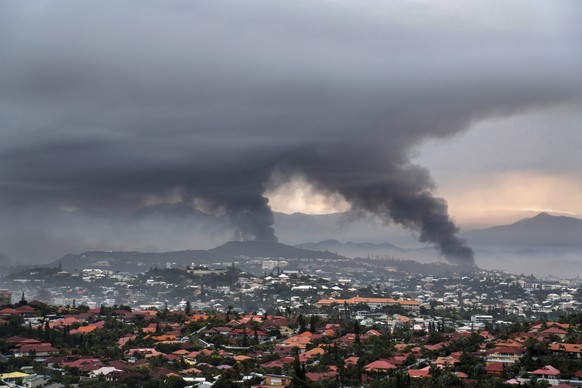 FILE - Smoke rises during protests in Noumea, New Caledonia, Wednesday May 15, 2024. France has imposed a state of emergency in the French Pacific territory of New Caledonia. The French prosecutor for ...