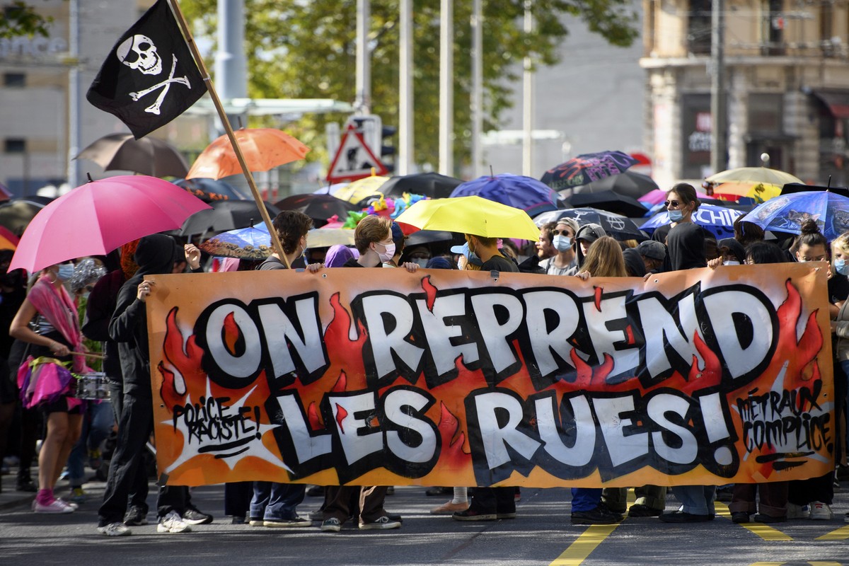 Des manifestants defilent avec des parapluies lors d'une manifestation pour le droit a manifester et contre la repression de la police ce samedi 25 septembre 2021 a Lausanne. (KEYSTONE/Laurent Gi ...