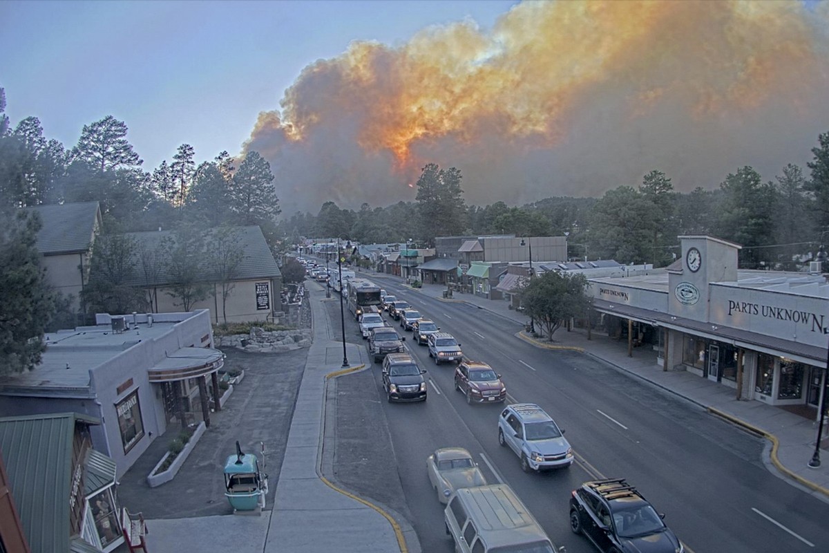 In this image taken from webcam footage provided by the Village of Ruidoso, smoke rises behind Ruidoso, N.M., on Monday, June 17, 2024. Thousands of southern New Mexico residents fled the mountainous  ...