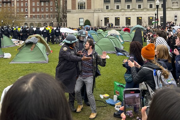 New York Police officers arrest a protestor who participated in an encampment on the Columbia University campus, Thursday, April 18, 2024, in New York. The protestors were calling for the school to di ...