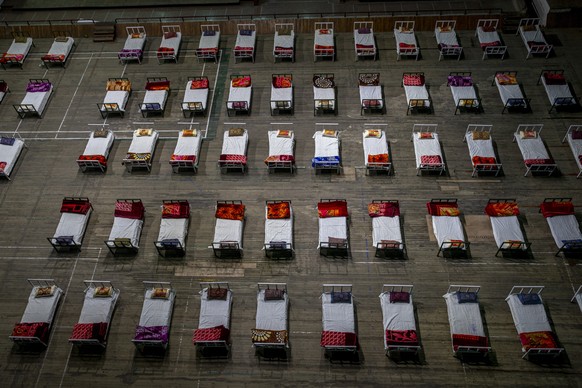 Beds lie inside an indoor stadium converted into COVID-19 treatment center for emergencies in the wake of the spike in the numbers of positive coronavirus cases in Srinagar, Indian controlled Kashmir, ...