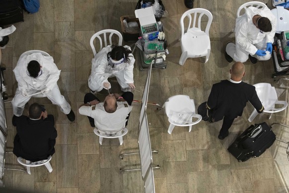 Medical personnel test travelers for COVID-19 as they arrive from abroad at the Ben-Gurion airport near Tel Aviv, Israel, Monday, March 1, 2021. (AP Photo/Sebastian Scheiner)