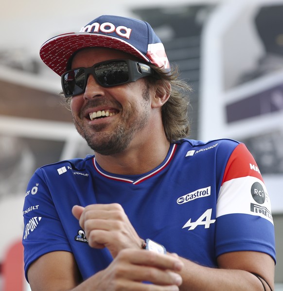 epa09638844 Spanish Formula One driver Carlos Sainz (L) of Scuderia Ferrari Mission Winnow and Spanish Formula One driver Fernando Alonso (R) of Alpine F1 Team react during the drivers track parade be ...