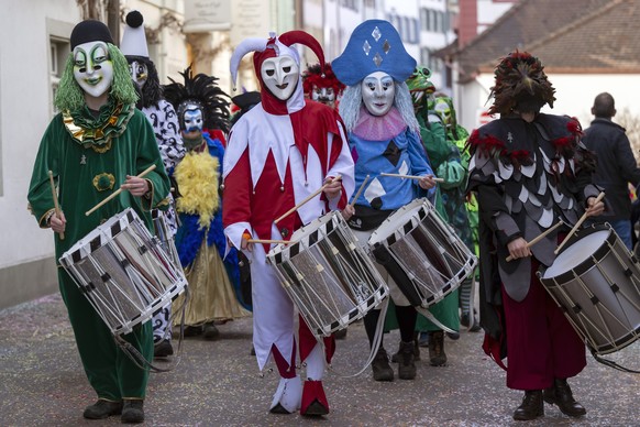 Eine Clique beim Gaessle an der Kinderfasnacht in Basel, am Dienstag, 24. Februar 2026. Am zweiten der drey scheenschte Daeaeg ueben sich die Binggis (Kinder) begleitet von Erwachsenen in der Pflege d ...