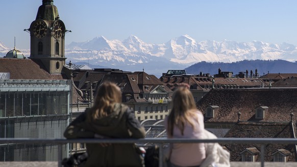 Zwei junge Frauen geniessen den Ausblick von der Grossen Schanze auf die Stadt und umliegenden Berge, am Mittwoch, 8. April 2015, in Bern. (KEYSTONE/Peter Klaunzer)