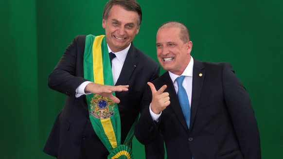 epa07257569 Brazilian newly inaugurated President Jair Bolsonaro (C) welcomes new Brazilian Chief Minister of the Civil House Onyx Lorenzoni (R), during his inauguration ceremony at the Planalto Palac ...