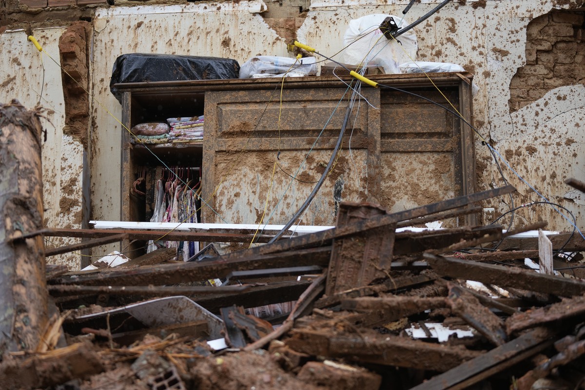 Clothes hang inside a muddied wardrobe at a destroyed home on the the third day of rescue efforts after mudslides in Petropolis, Brazil, Friday, Feb. 18, 2022. (AP Photo/Silvia Izquierdo)