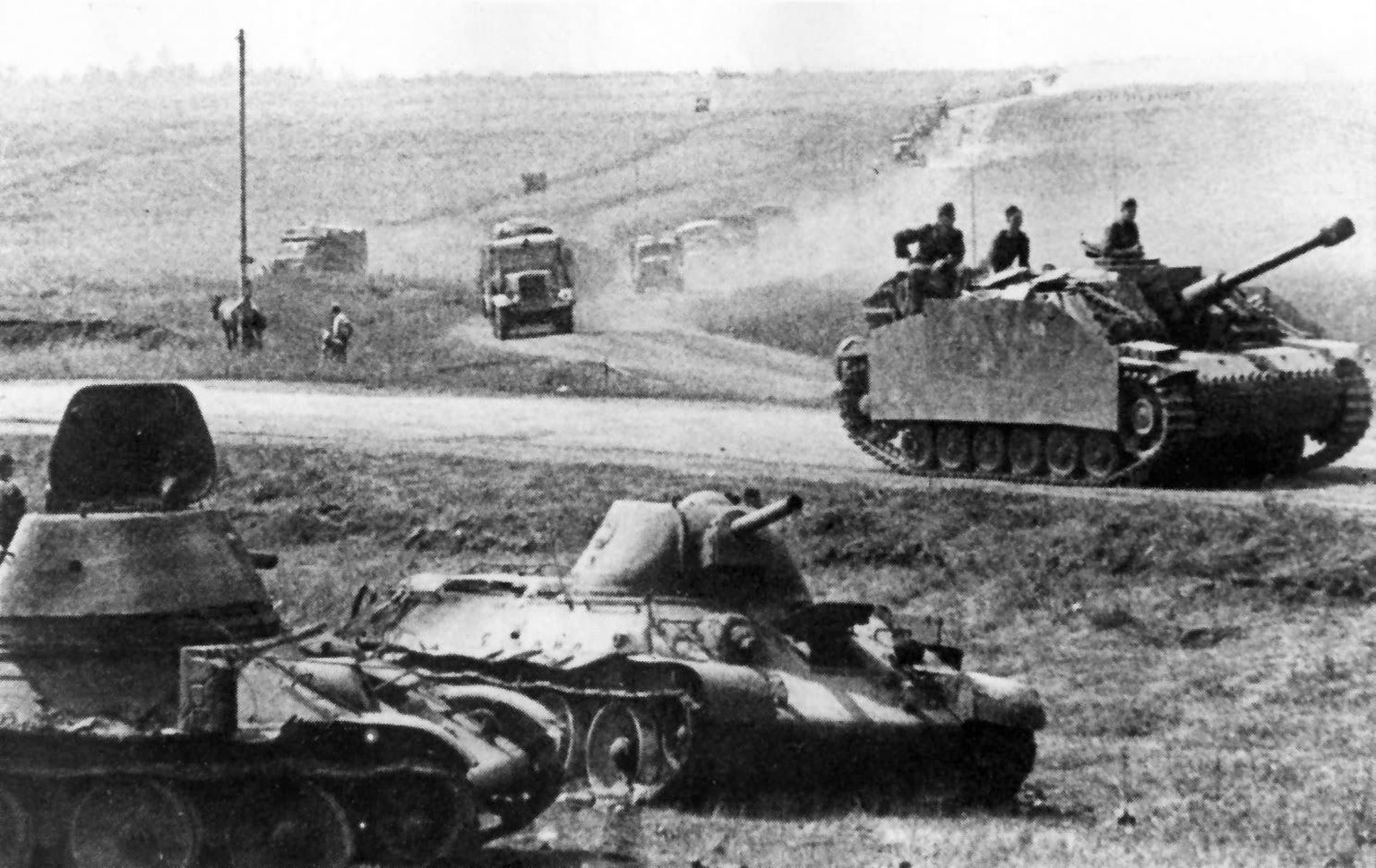 Deutsches Sturmgeschütz fährt in der Schlacht bei Kursk an zwei kampfunfähigen T-34 vorbei.